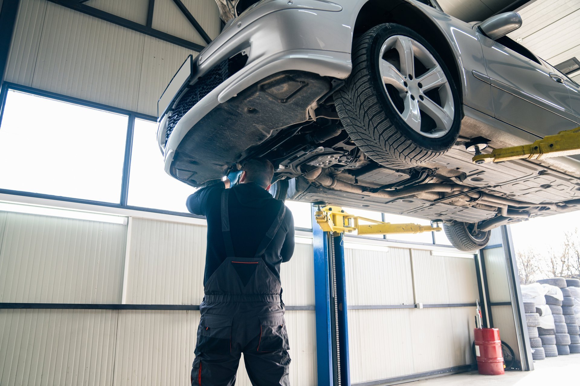 Mechanic checking car suspension on a lift